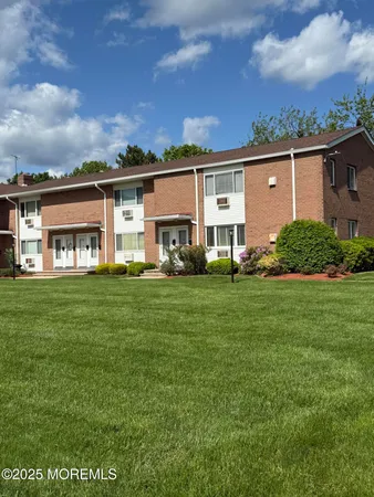 a view of a house with a big yard and large trees