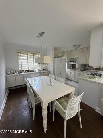 a kitchen with a dining table chairs and cabinets