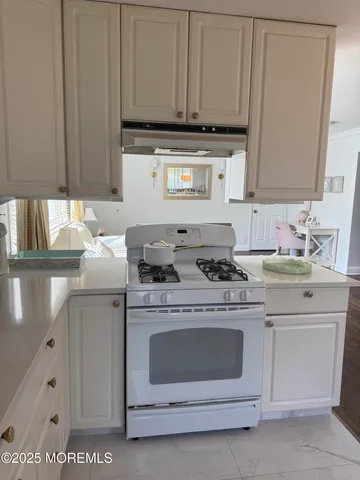 a kitchen with granite countertop white cabinets and white appliances