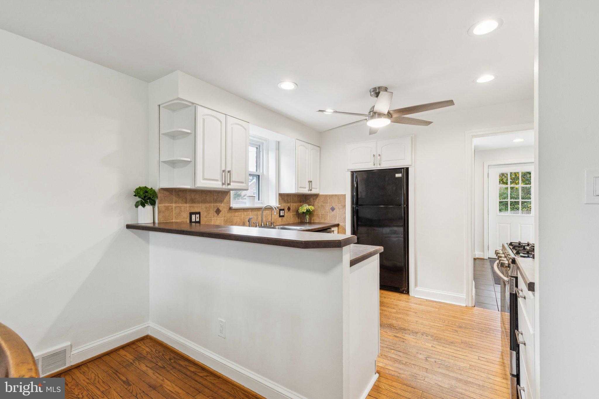 222 Harrogate Road Wynnewood, PA 19096 - Photo 12 of 43 a kitchen with stainless steel appliances a sink dishwasher a refrigerator and cabinets with wooden floor