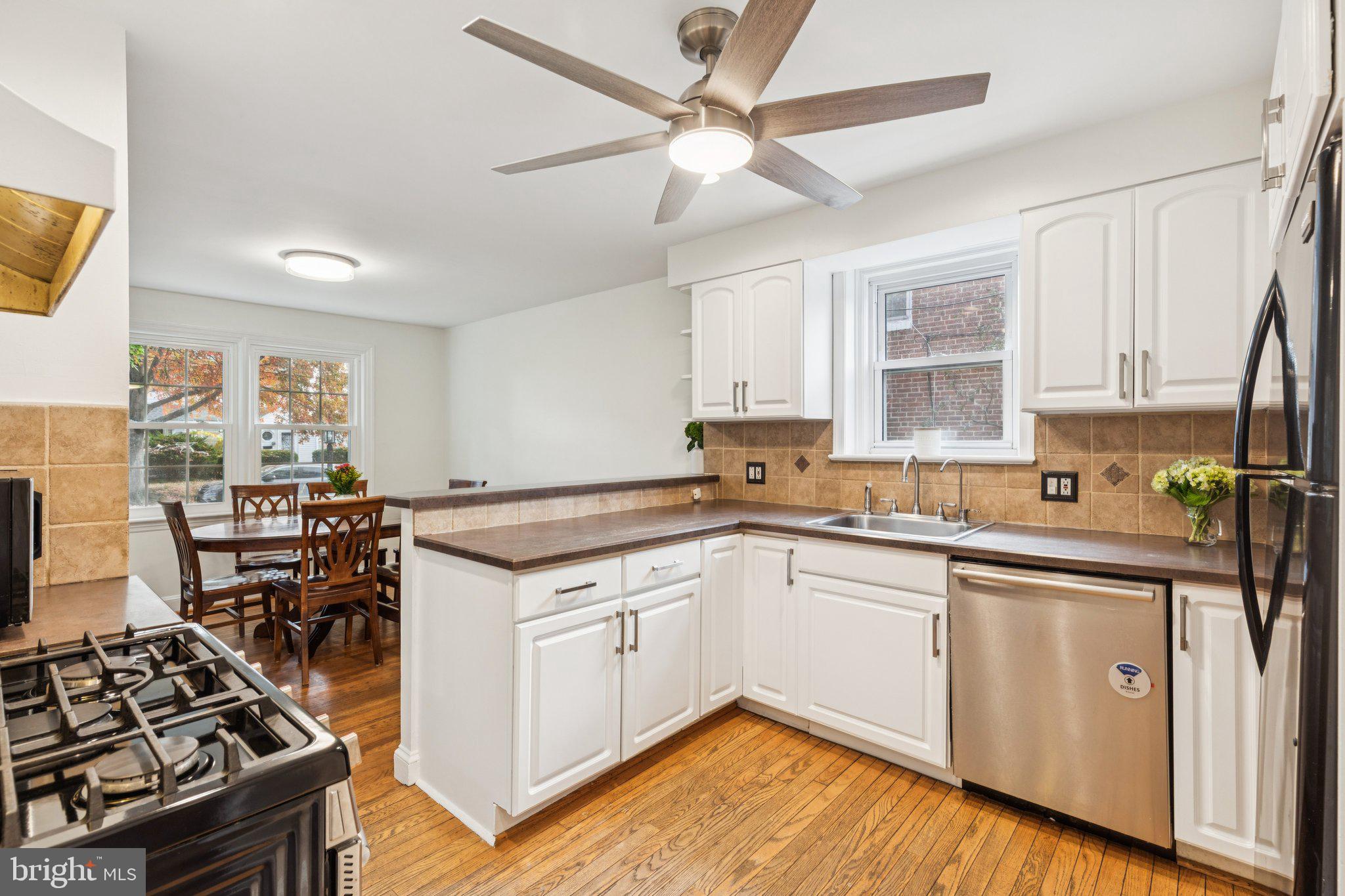 222 Harrogate Road Wynnewood, PA 19096 - Photo 15 of 43 a kitchen with a stove a sink a window and dining table