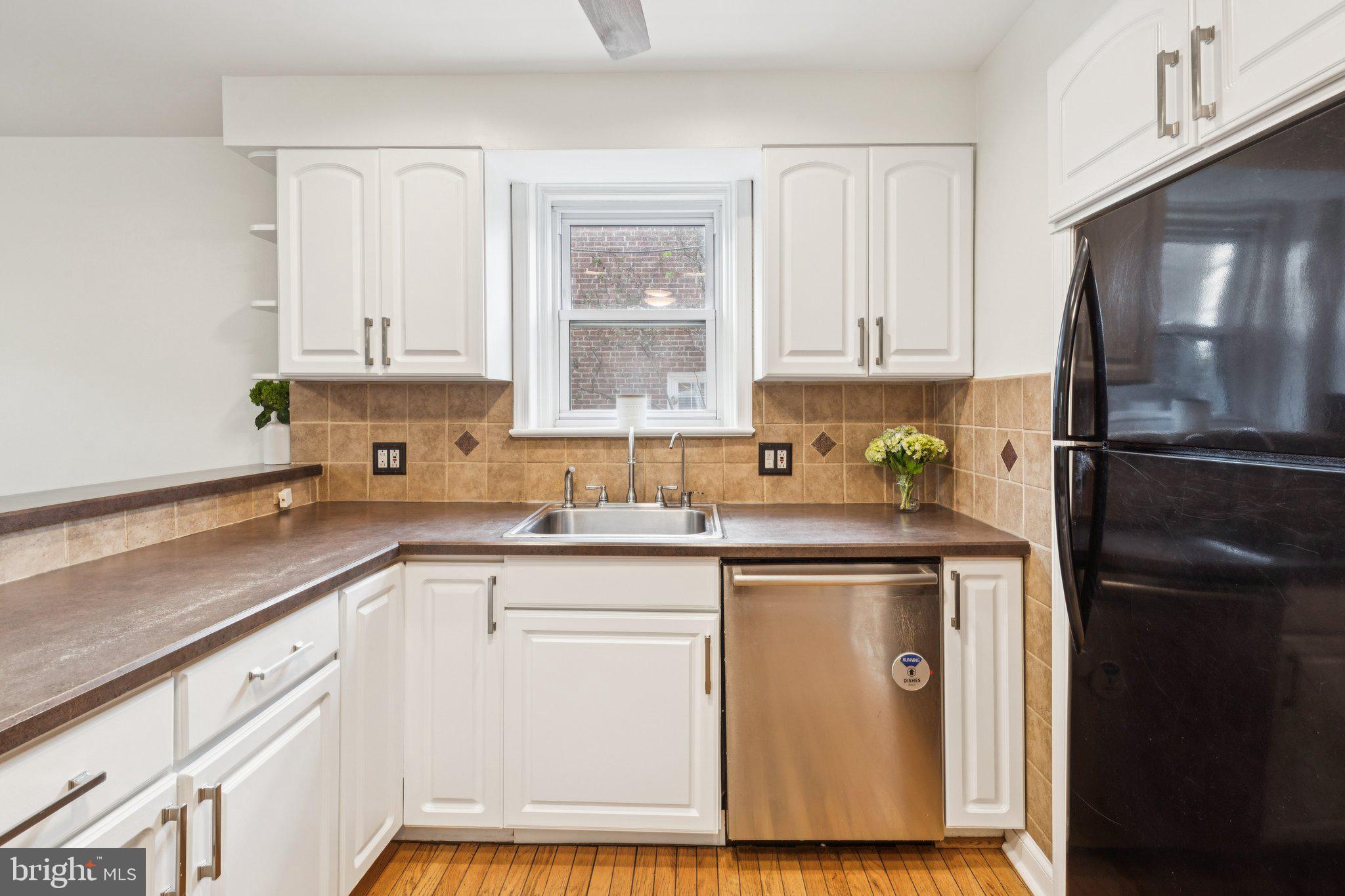 222 Harrogate Road Wynnewood, PA 19096 - Photo 16 of 43 a kitchen with stainless steel appliances granite countertop a refrigerator a sink a stove and white cabinets with wooden floor