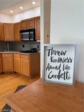 a kitchen with stainless steel appliances granite countertop a stove top oven a sink and a microwave