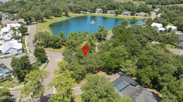 an aerial view of residential house with outdoor space and trees all around