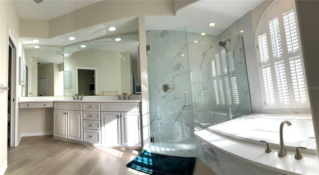 8870 Huntington Pointe Drive Sarasota, FL 34238 - Photo 12 of 28 a bathroom with a granite countertop sink a large mirror and shower