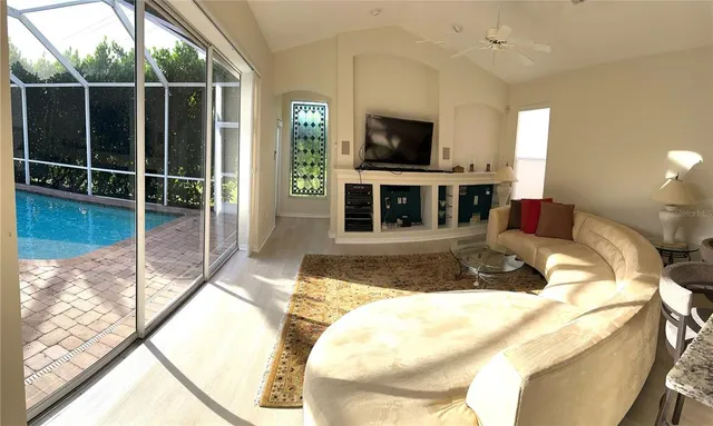 a living room with furniture flat screen tv and a floor to ceiling window