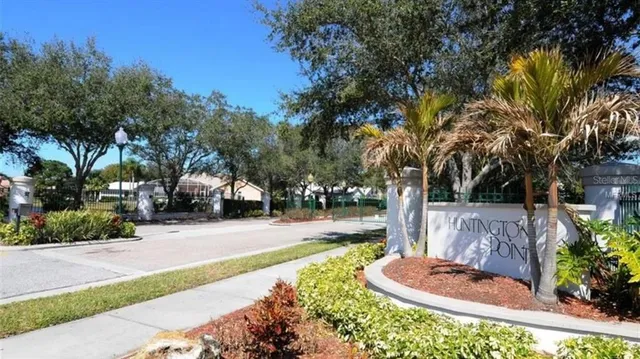 a front view of a house with fountain and trees
