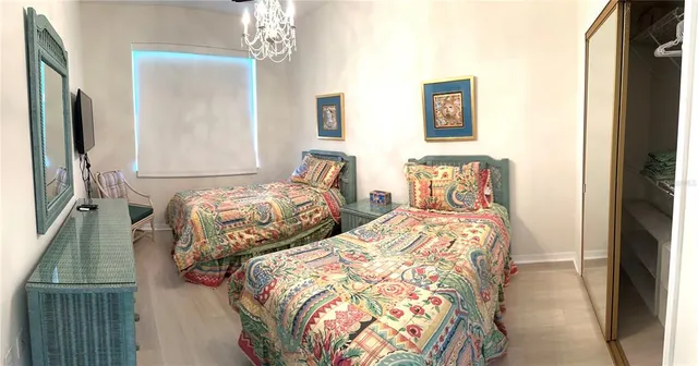 a bedroom with two beds and a chandelier