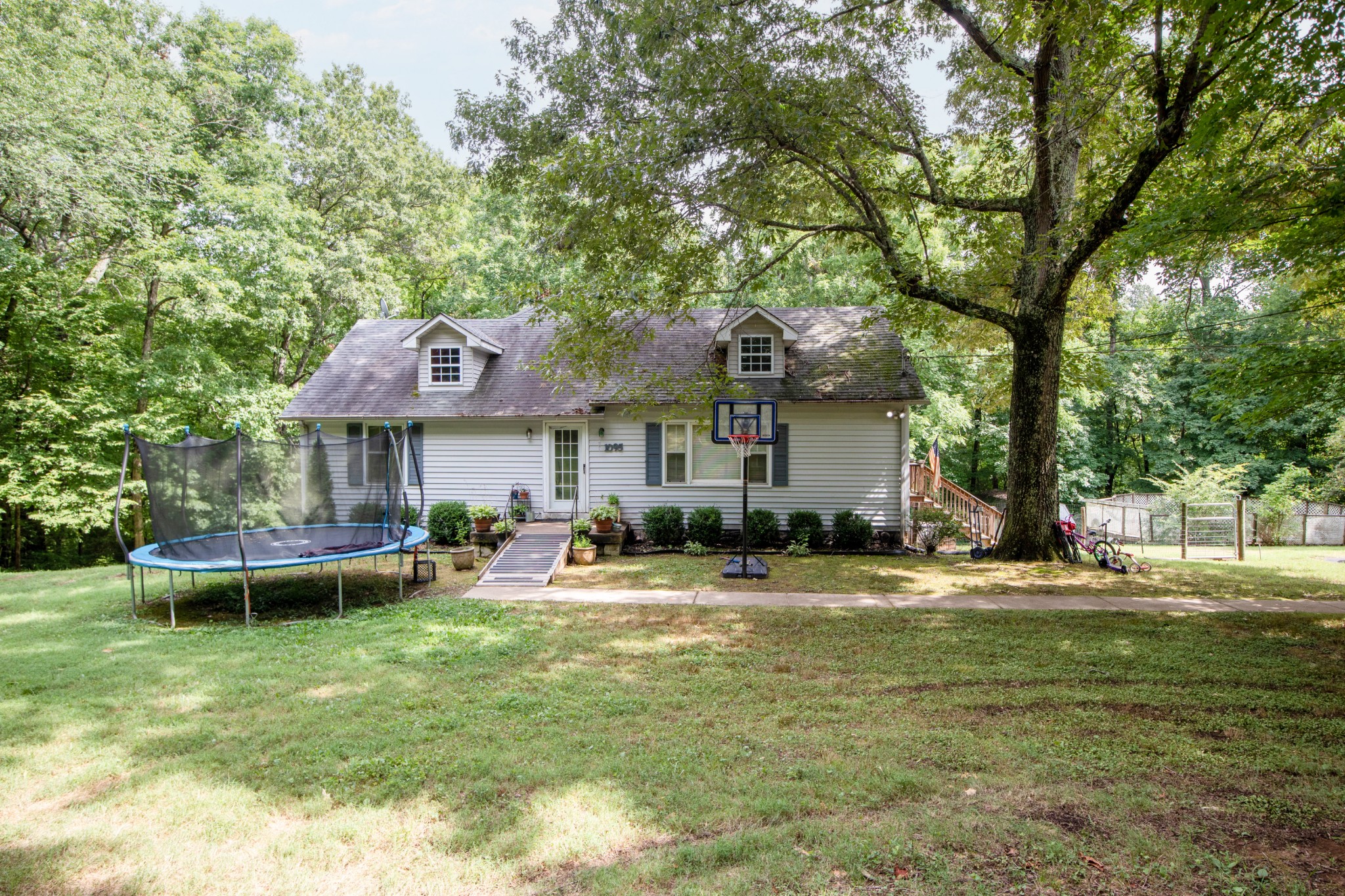 1095 Porter Road Burns, TN 37029 - Photo 32 of 34 a front view of a house with a garden and trees