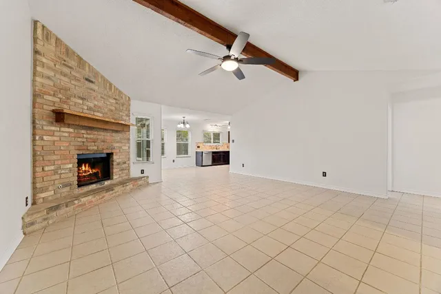 a view of a livingroom with a fireplace and a ceiling fan
