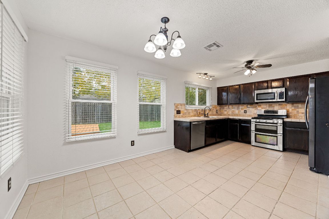 2602 Armstrong Drive Leander, TX 78641 - Photo 7 of 22 a large white kitchen with a large window a sink and stainless steel appliances