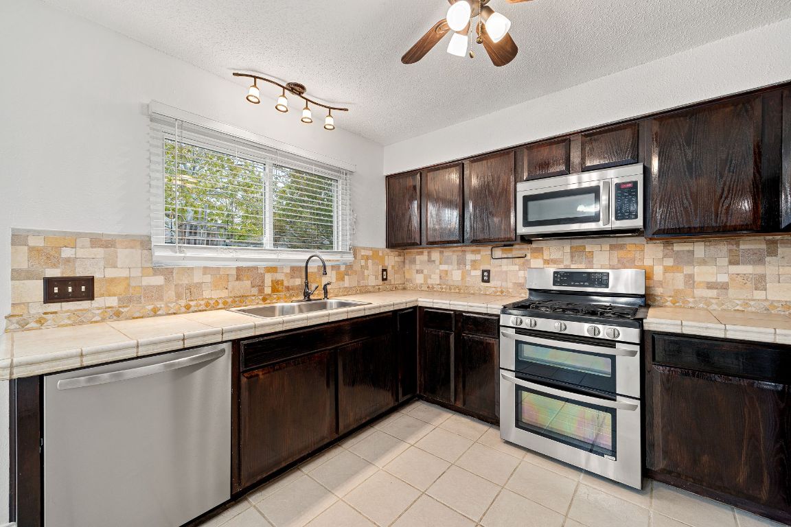 2602 Armstrong Drive Leander, TX 78641 - Photo 8 of 22 a kitchen with stainless steel appliances granite countertop a sink and stove top oven