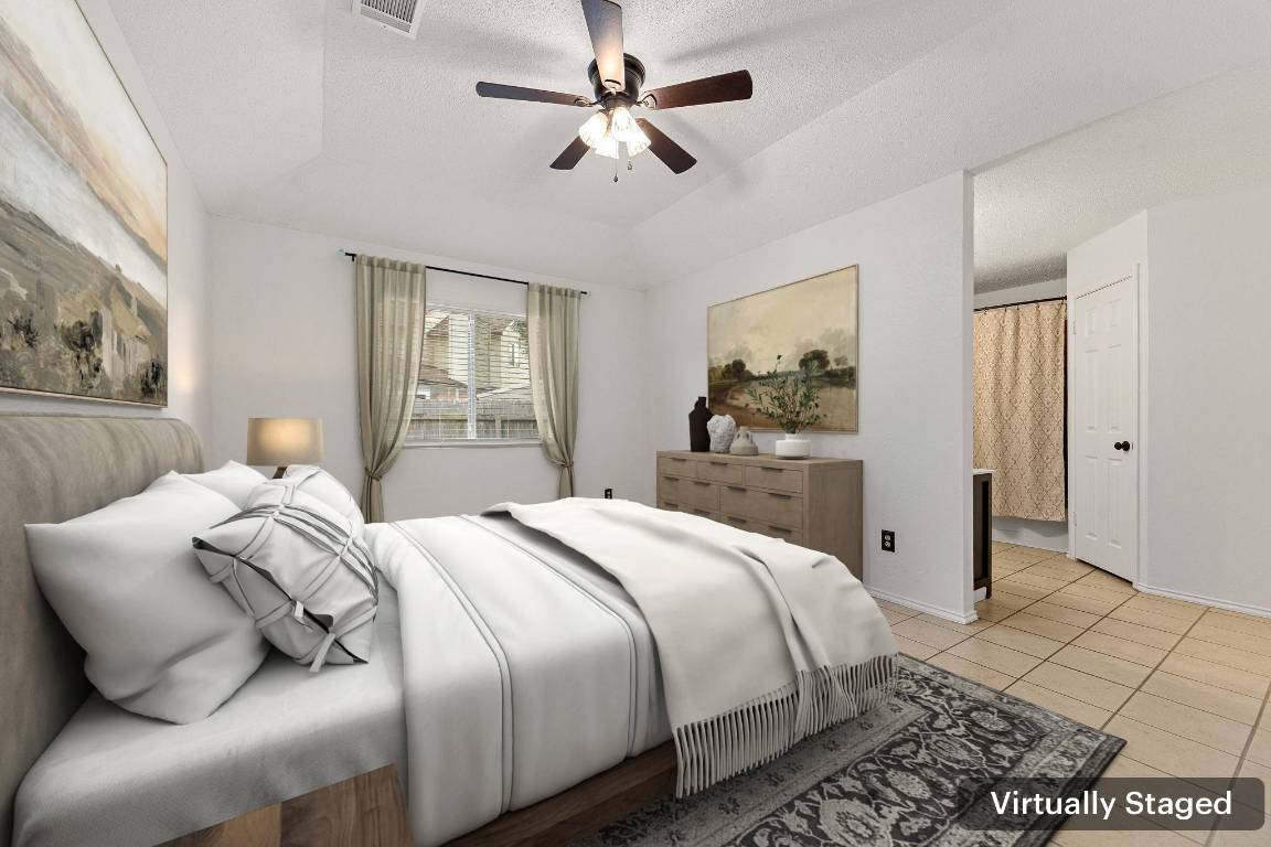 2602 Armstrong Drive Leander, TX 78641 - Photo 10 of 22 a bedroom with a large bed and a chandelier