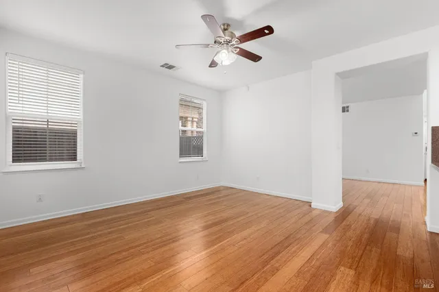 a kitchen with stainless steel appliances granite countertop a stove a refrigerator a sink a dining table and chairs