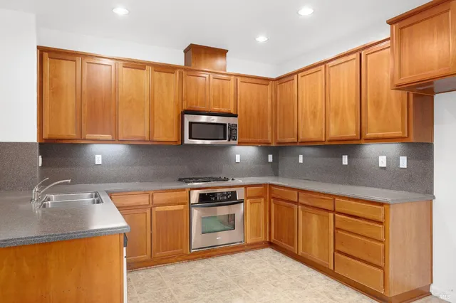 a kitchen with stainless steel appliances granite countertop a sink stove and microwave