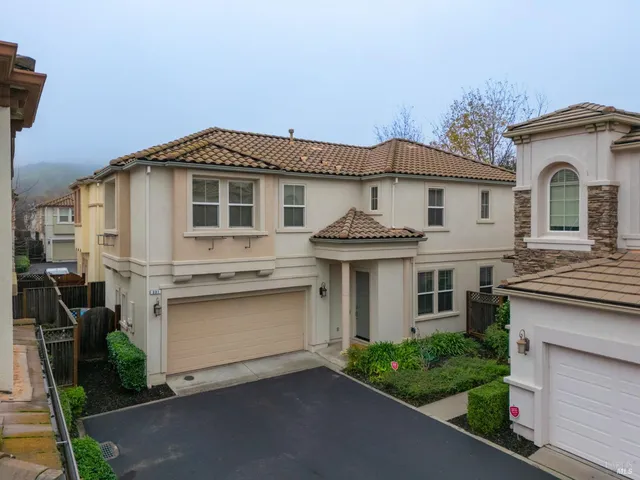 an aerial view of a house with yard and mountain view in back