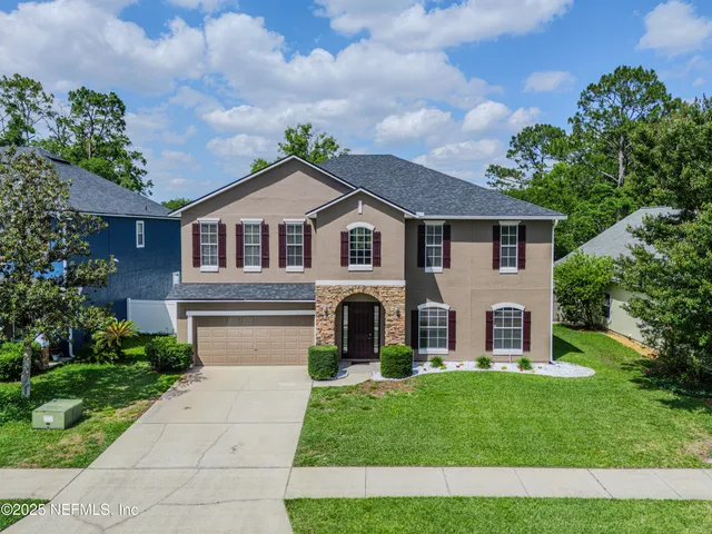 a front view of a house with a garden and plants