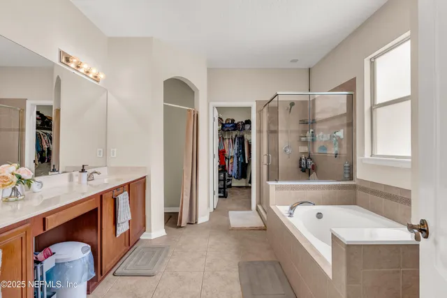 a bathroom with a tub sink and mirror