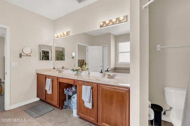 a spacious bathroom with a double vanity sink and a mirror
