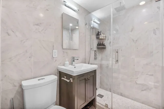 a bathroom with a sink a toilet and shower