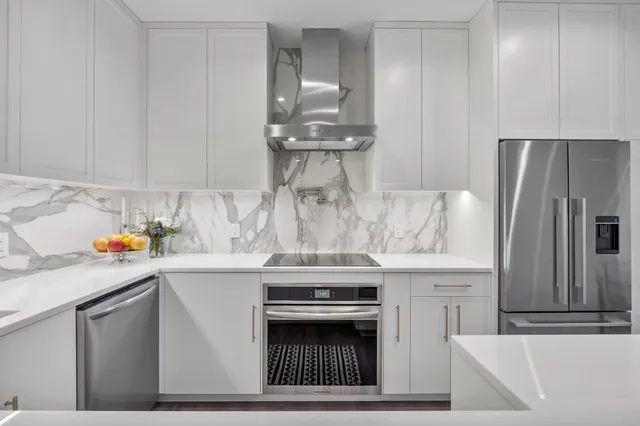 a kitchen with stainless steel appliances kitchen island a sink stove and refrigerator