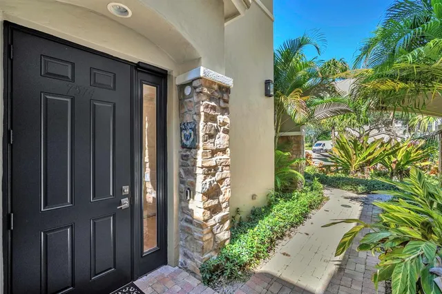 a living room with patio furniture and a potted plant
