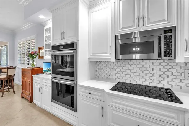 a kitchen with white cabinets and stainless steel appliances