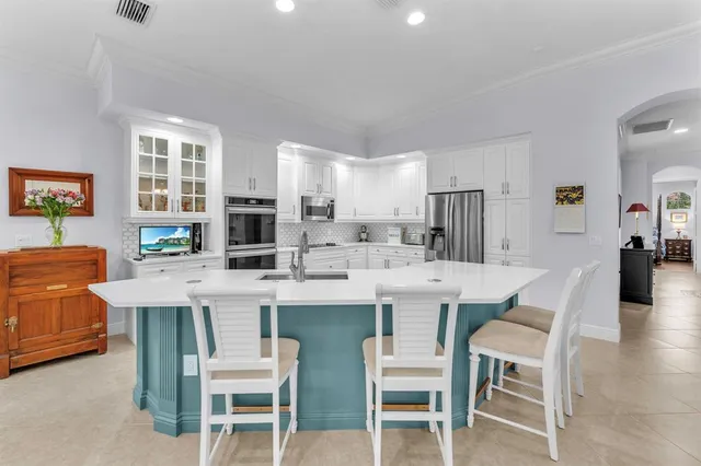 a living room with stainless steel appliances furniture and a view of kitchen