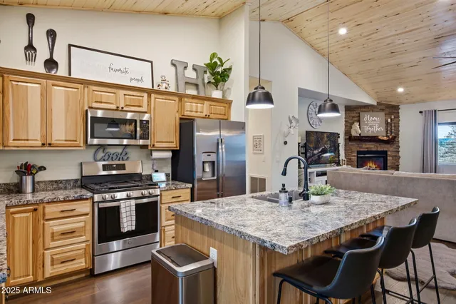 a kitchen with kitchen island granite countertop a sink and a stove