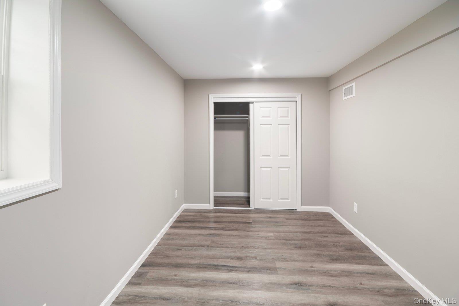 568 Granny Road Medford, NY 11763 - Photo 15 of 22 Unfurnished bedroom featuring light wood-type flooring and a closet