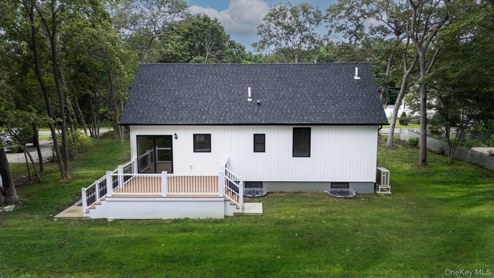568 Granny Road Medford, NY 11763 - Photo 17 of 22 Back of house featuring a shingled roof, a yard, and a wooden deck