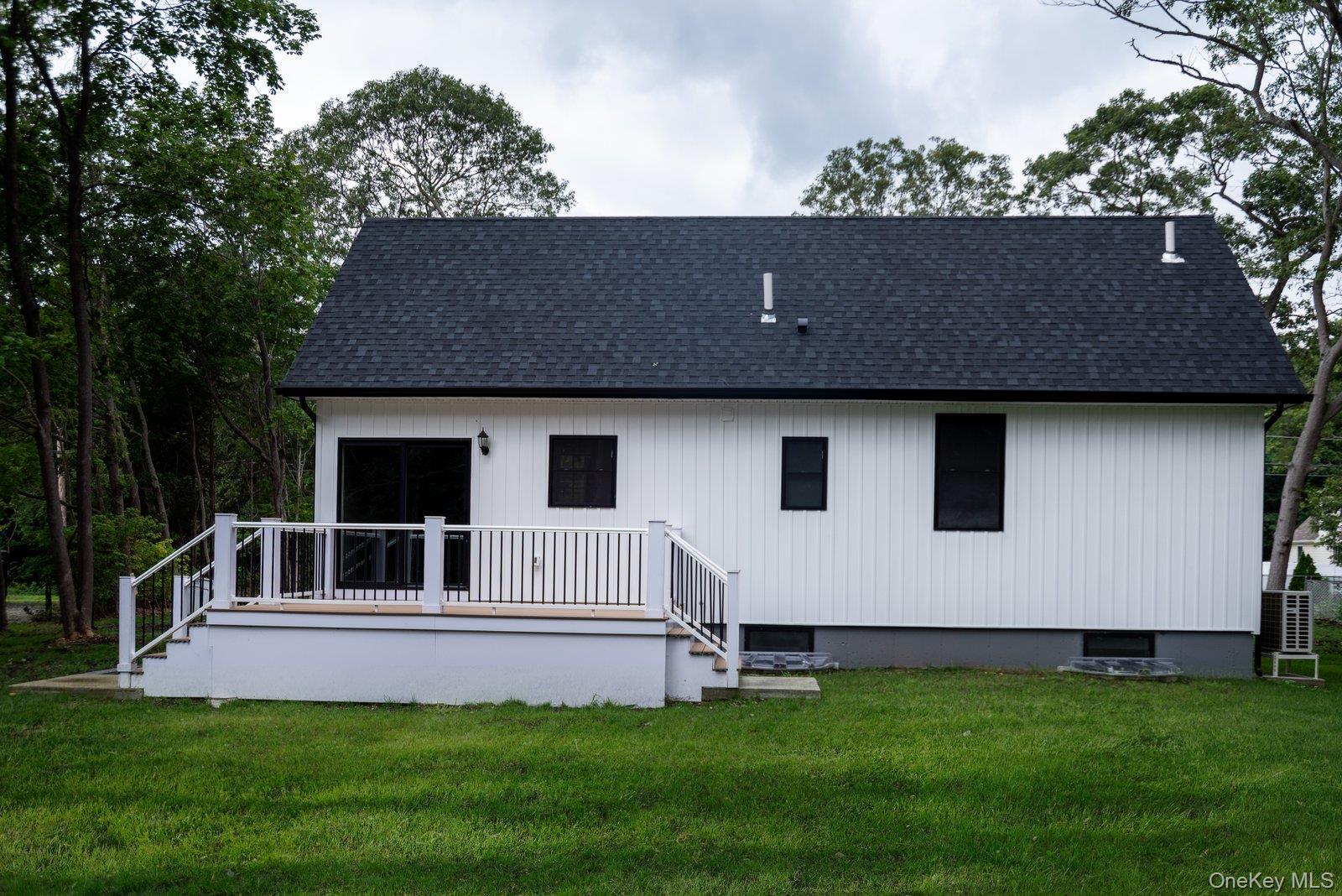 568 Granny Road Medford, NY 11763 - Photo 18 of 22 Back of property featuring a yard, a deck, and roof with shingles