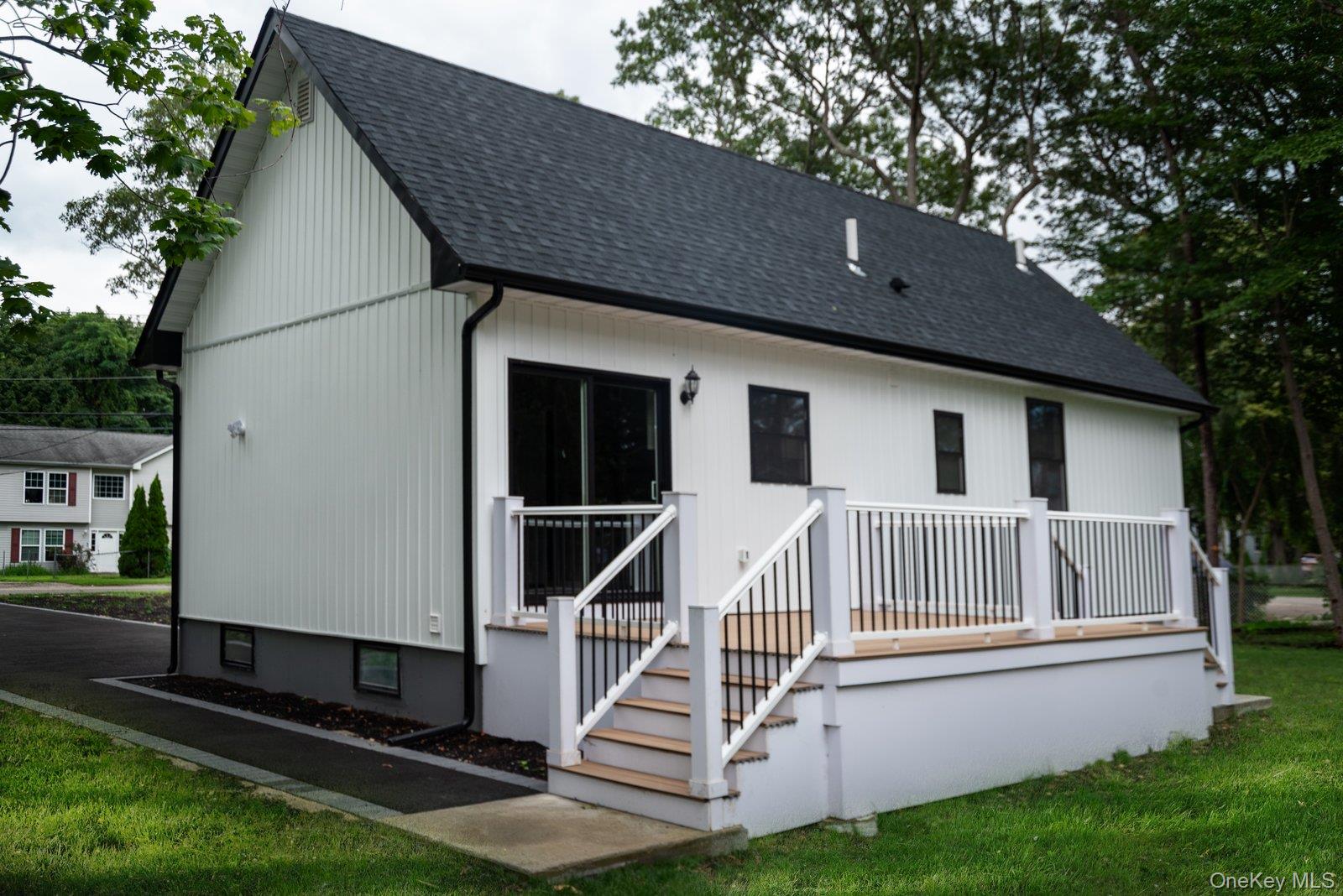 568 Granny Road Medford, NY 11763 - Photo 19 of 22 Rear view of house with a shingled roof, a deck, and a lawn