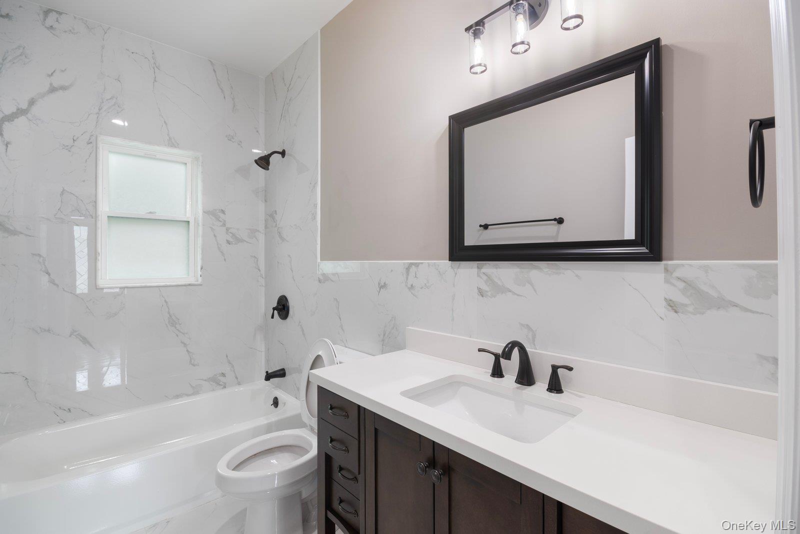 568 Granny Road Medford, NY 11763 - Photo 7 of 22 Full bath with bathtub / shower combination, vanity, tile walls, and a wainscoted wall