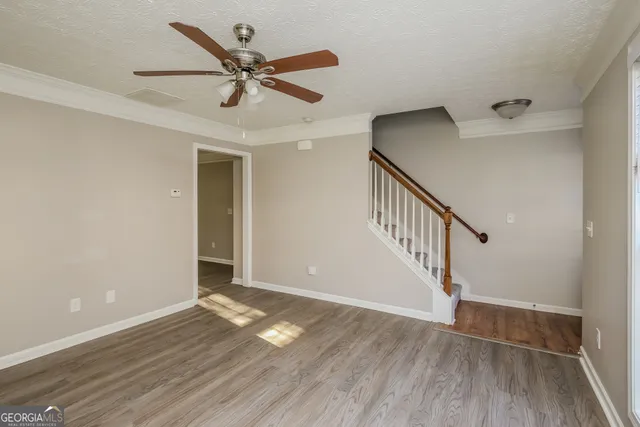 a view of room with hardwood floor and ceiling fan