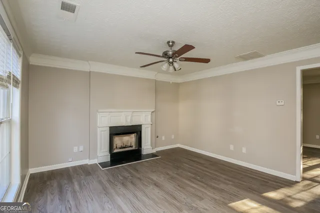 a view of wooden floor a chandelier and a fireplace in room
