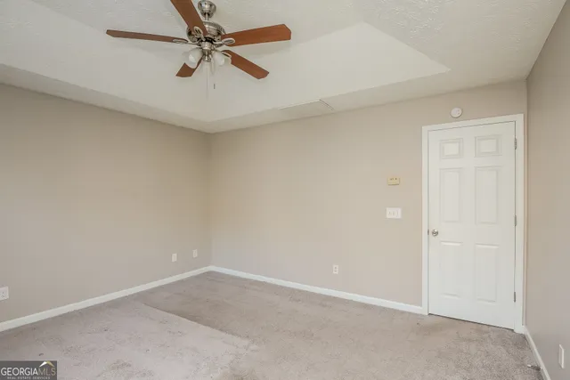 an empty room with a ceiling fan and a window