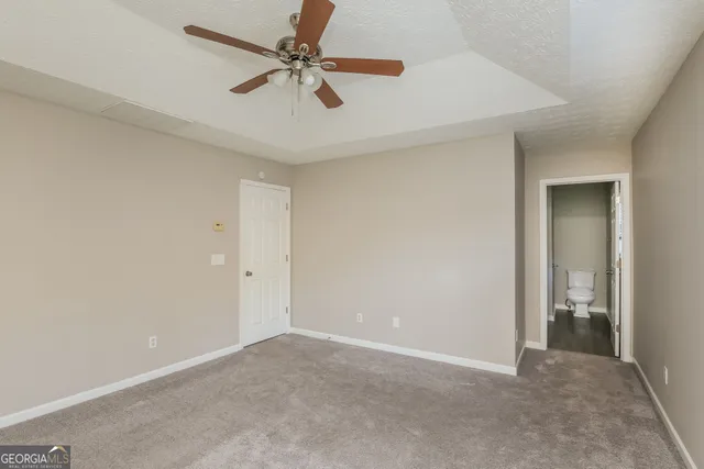 an empty room with closet and a chandelier fan
