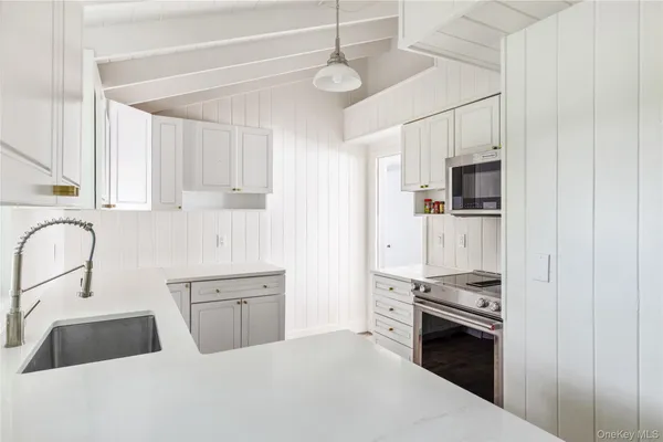 a kitchen with stainless steel appliances a sink stove and cabinets
