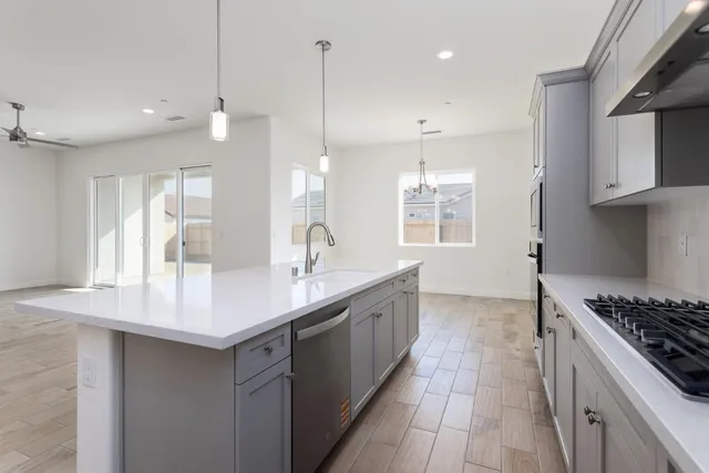 a kitchen with a sink stove top oven and cabinets