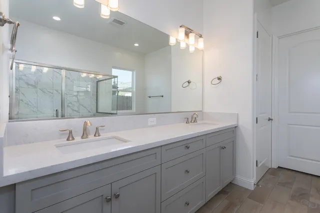 a bathroom with a double vanity sink and a mirror