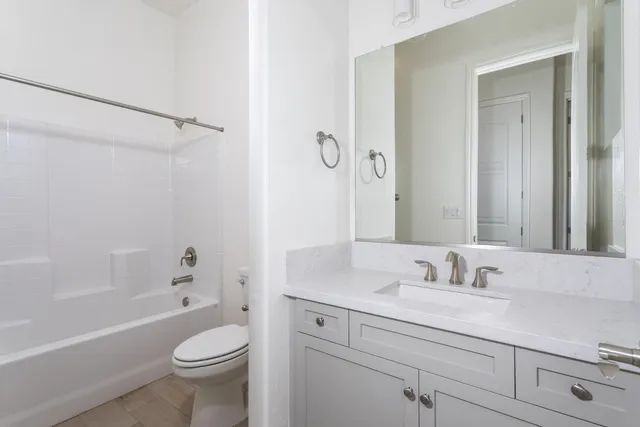 a bathroom with a sink a toilet a mirror a bathtub and shower