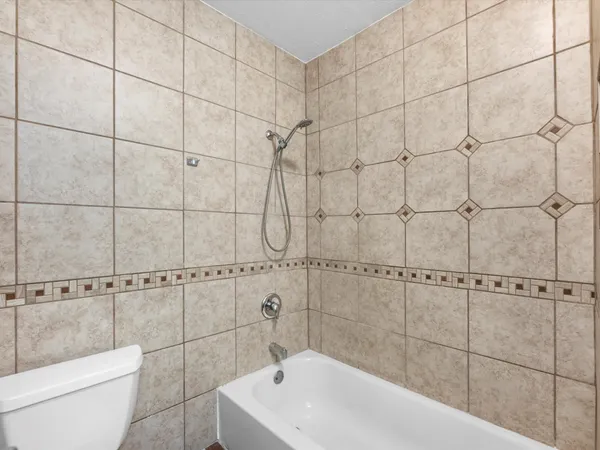 a white bath tub sitting next to a white toilet and a shower