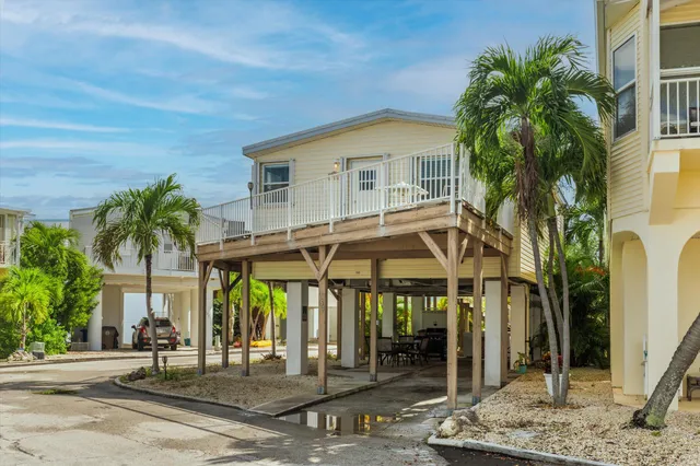 a patio with table and chairs and potted plants
