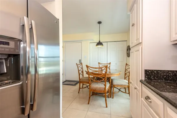 a kitchen with a refrigerator and table chair