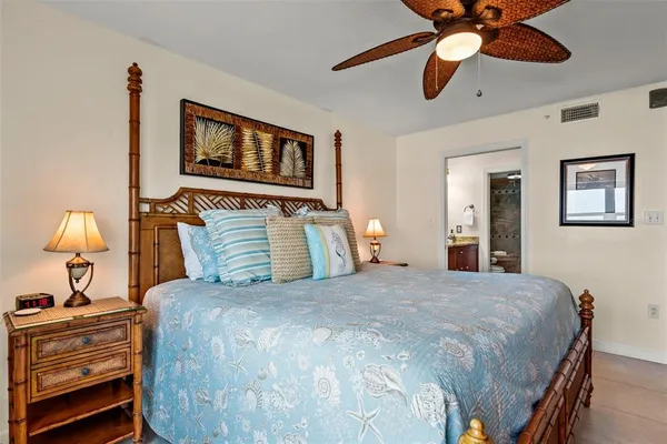 a bedroom with a bed and lamp painting on the wall