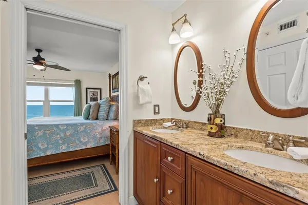 a bathroom with a granite countertop sink a mirror and a shower