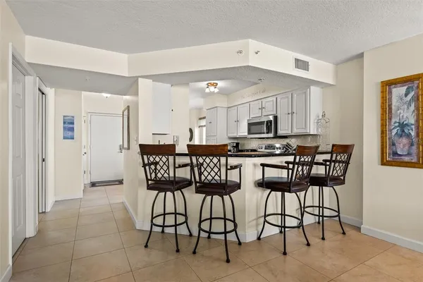 a kitchen with stainless steel appliances kitchen island granite countertop a refrigerator and cabinets
