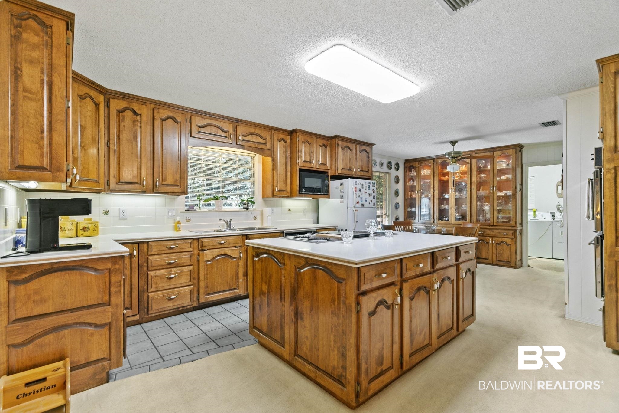 752 Evergreen Street Fairhope, AL 36532 - Photo 14 of 100 Kitchen featuring light countertops, brown cabinetry, a kitchen island, separate washer and dryer, and ceiling fan