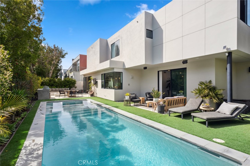 a view of a patio with couches table and chairs with plants and garden
